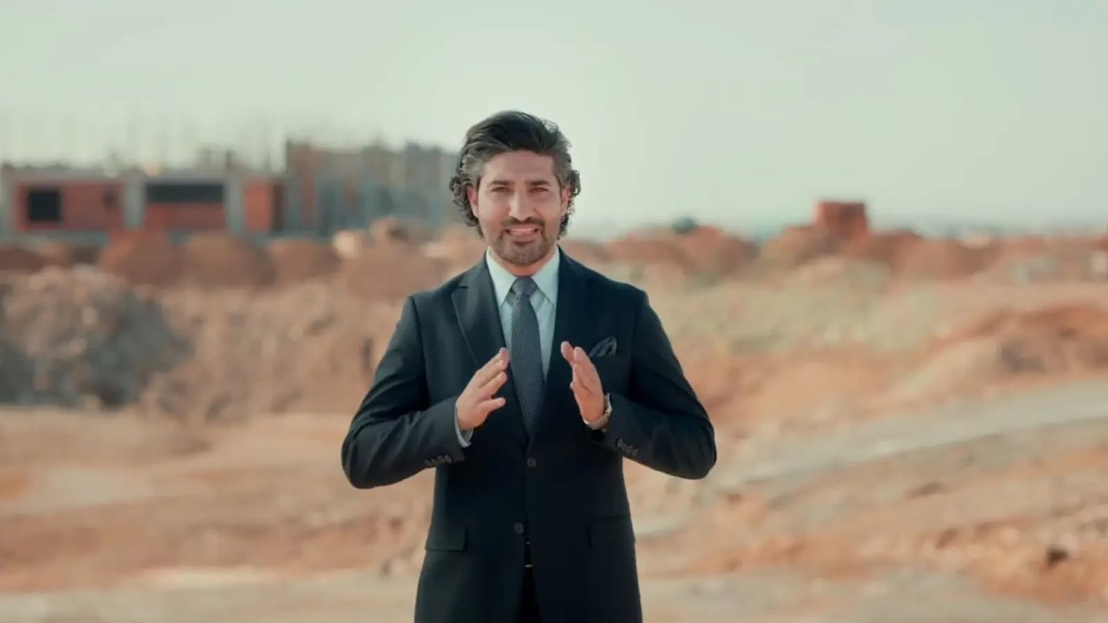 On site: the presenter among the half-built villas.